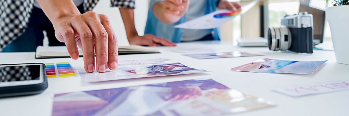 two teammates design branding materials at a table